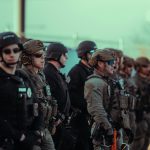 Heavily armed police officers standing in a line.